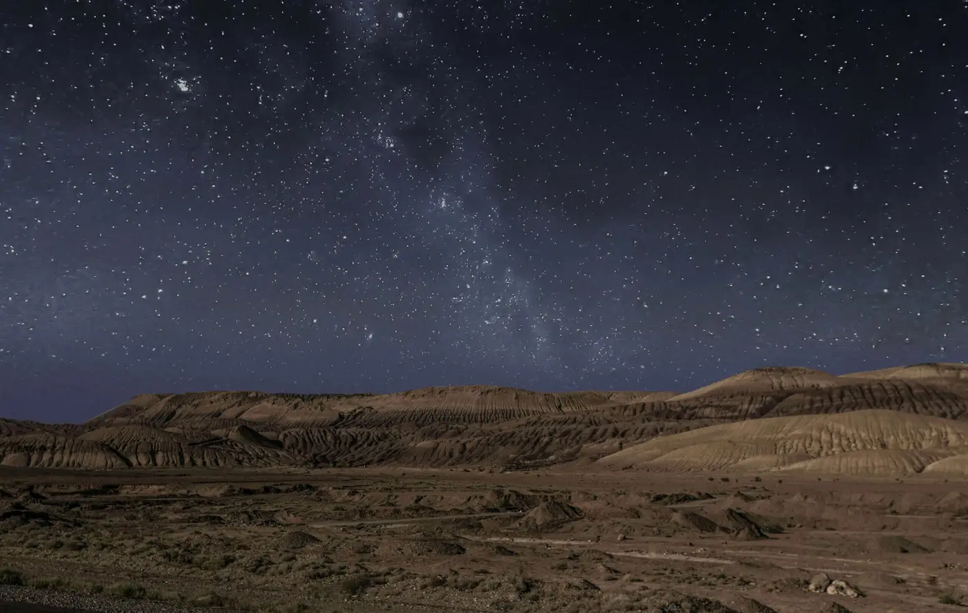 a starry sky above a desert in Doha